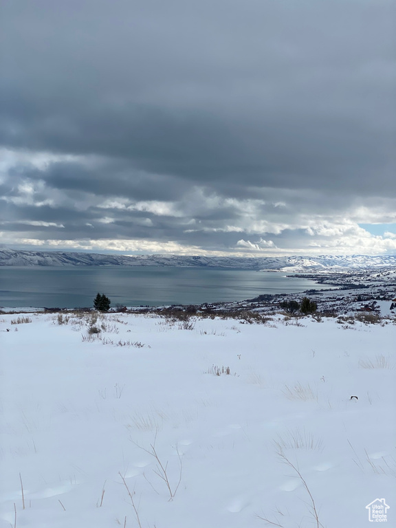 Snowy yard featuring a water view