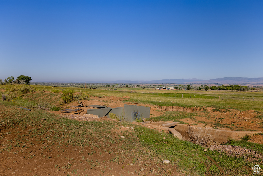 View of yard with a rural view and a mountain view