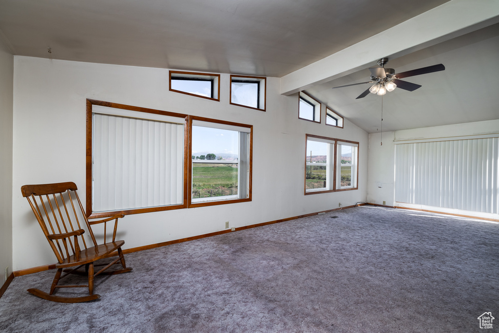 Unfurnished room featuring ceiling fan, carpet, and lofted ceiling with beams