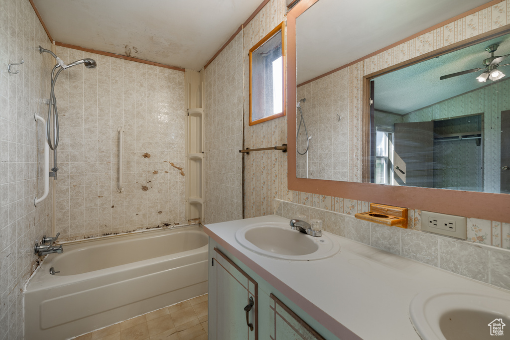 Bathroom featuring tiled shower / bath combo, vanity, backsplash, and ceiling fan