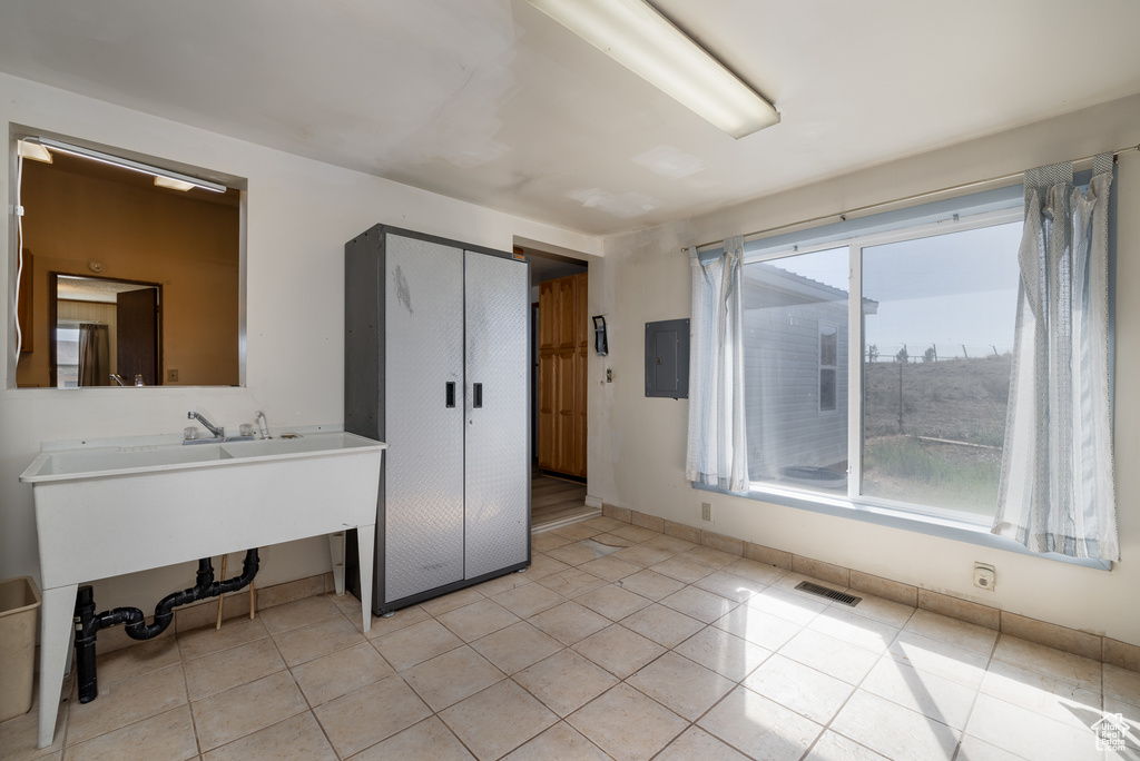 Laundry room featuring light tile patterned floors and electric panel