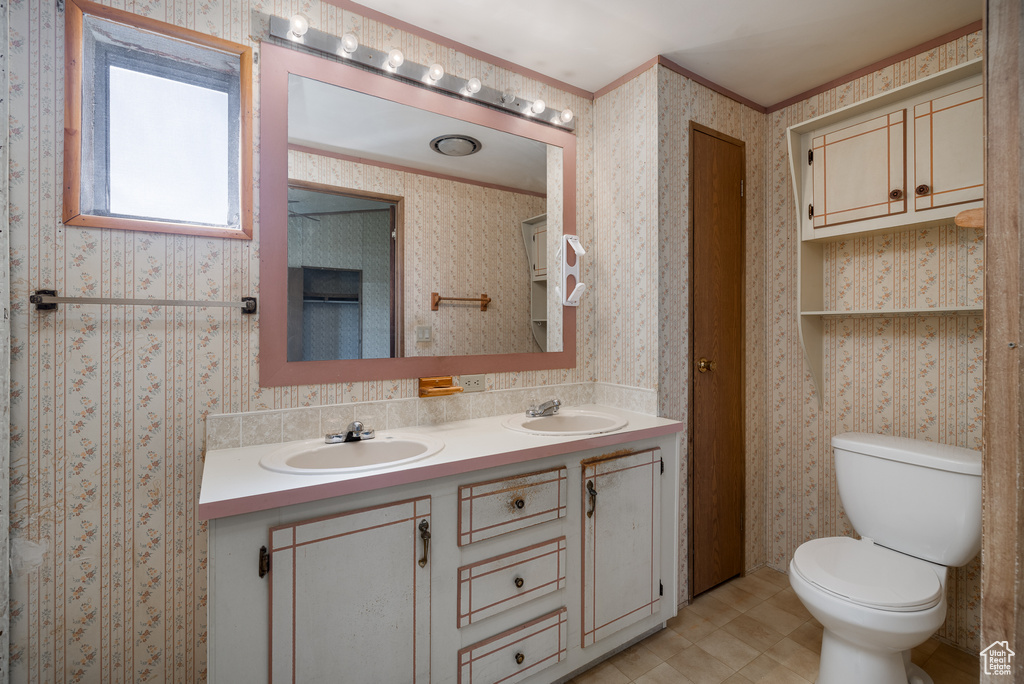 Bathroom featuring vanity, toilet, and tile patterned flooring