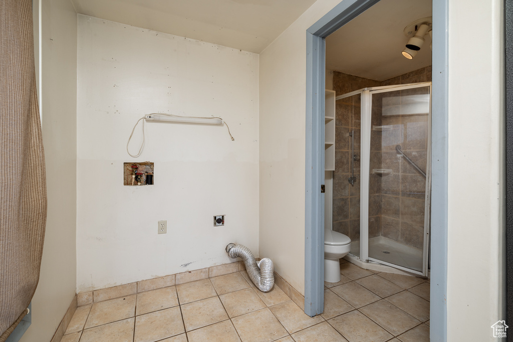 Washroom with washer hookup, light tile patterned floors, and electric dryer hookup
