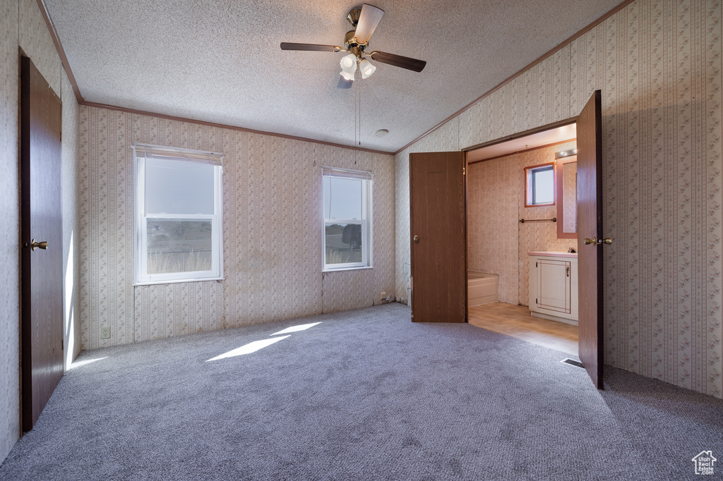 Unfurnished bedroom with ceiling fan, crown molding, light carpet, and vaulted ceiling