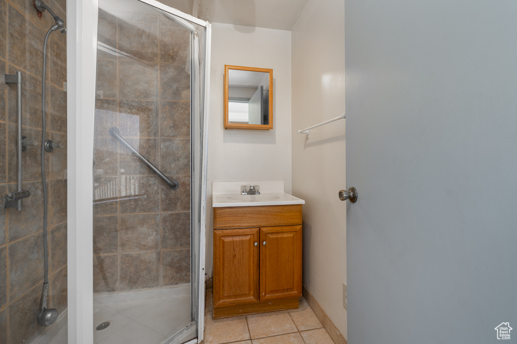 Bathroom featuring tile patterned floors, walk in shower, and vanity