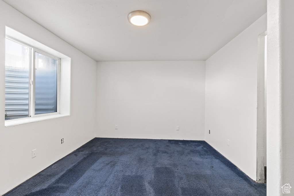 Unfurnished room with dark carpet