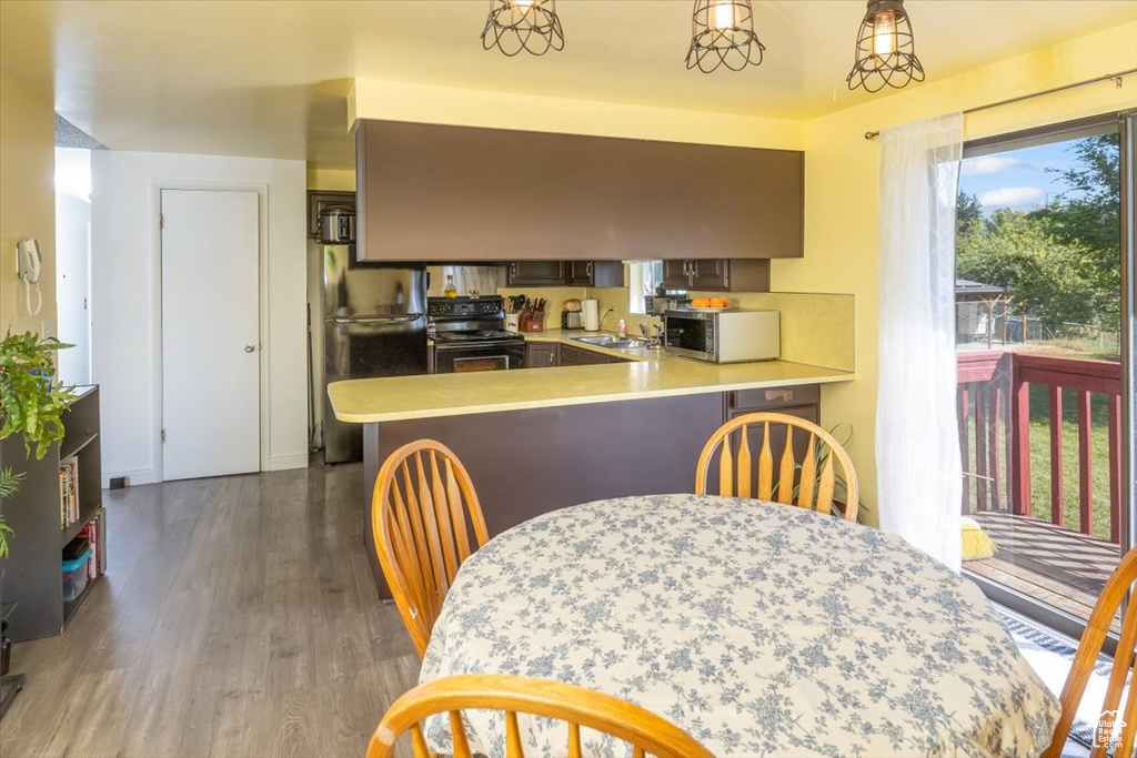 Kitchen with dark wood-type flooring, stainless steel appliances, sink, and kitchen peninsula