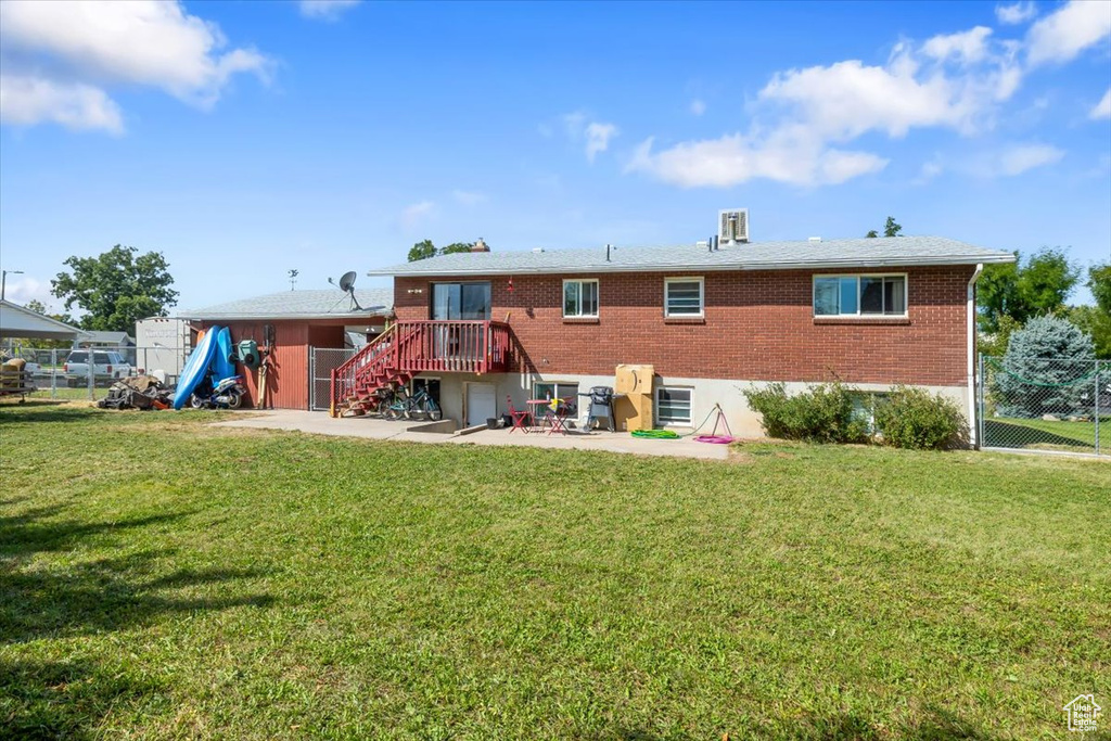 Back of house with a yard and a patio area