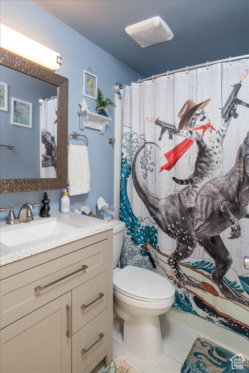 Bathroom with vanity, toilet, a shower with curtain, and tile patterned flooring