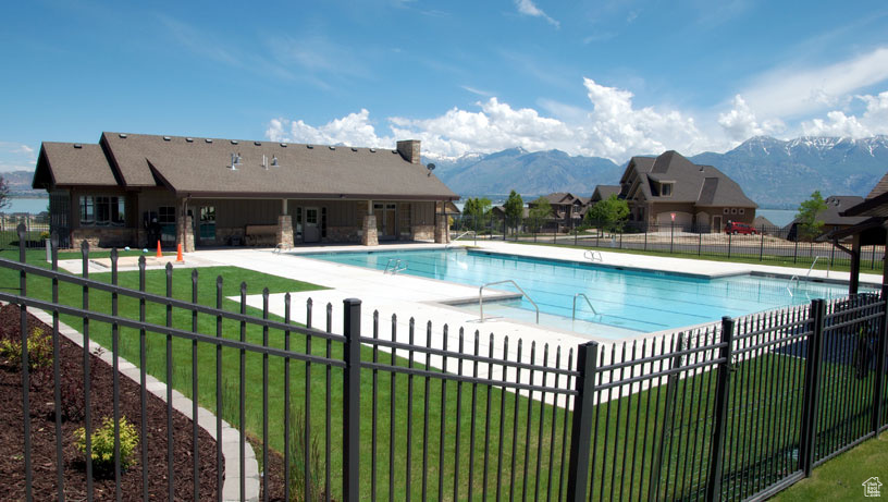 View of swimming pool with a lawn, a patio area, and a mountain view