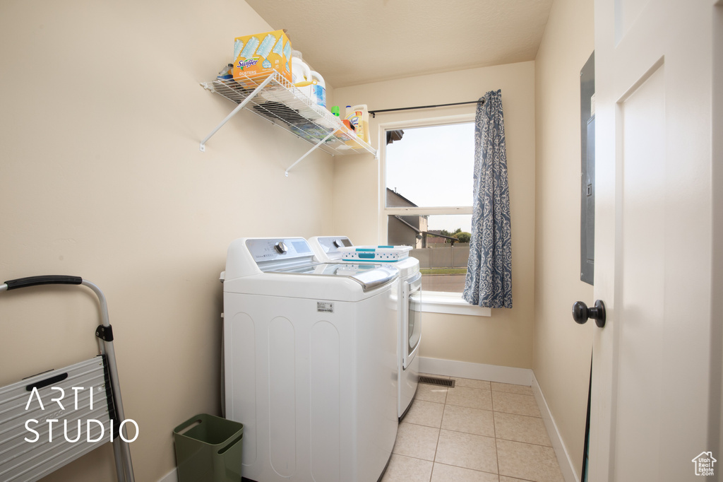 Washroom featuring washer and dryer and light tile patterned floors