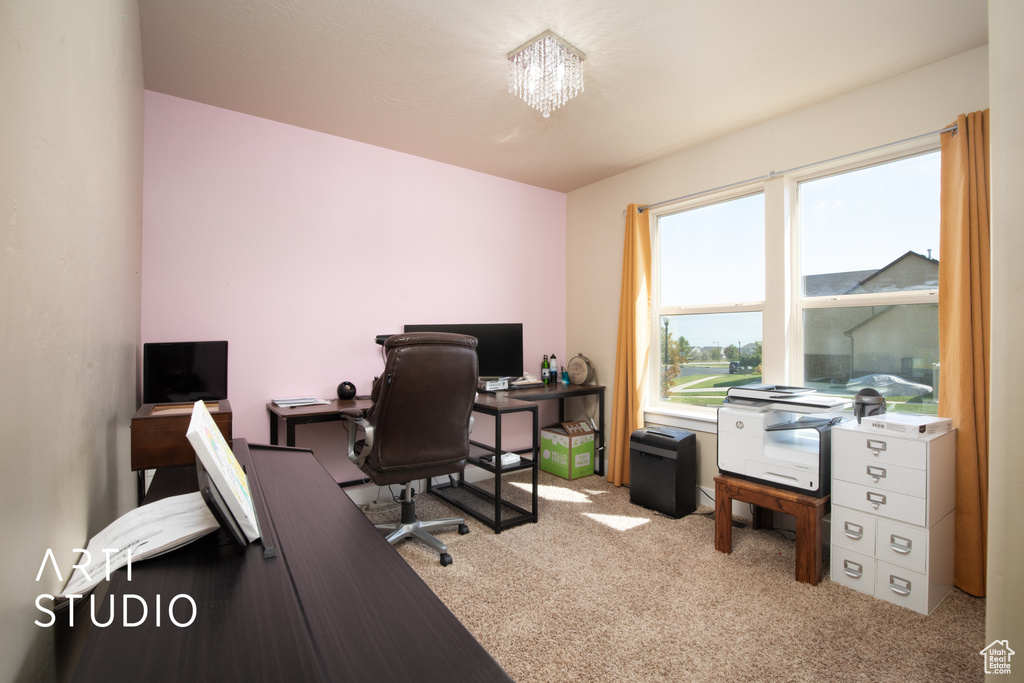 Office featuring light colored carpet and a notable chandelier