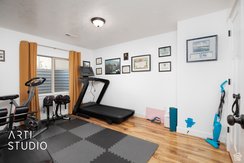 Workout room featuring hardwood / wood-style flooring and a textured ceiling