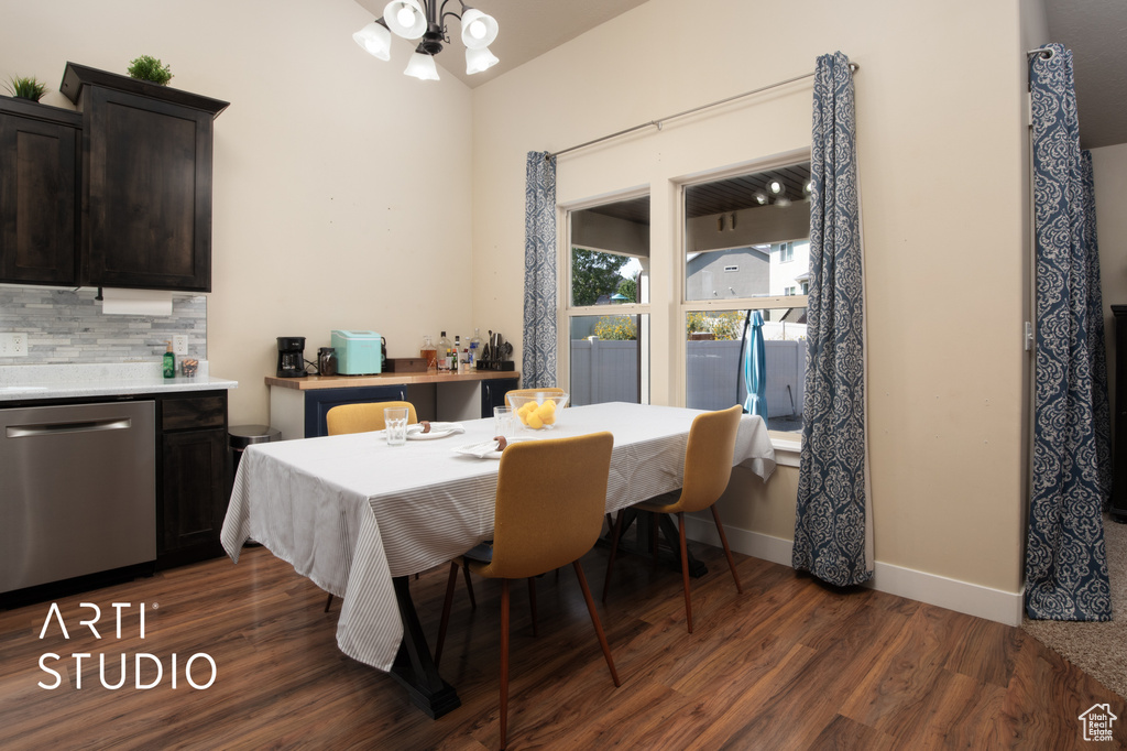 Dining room with dark wood-type flooring and a chandelier