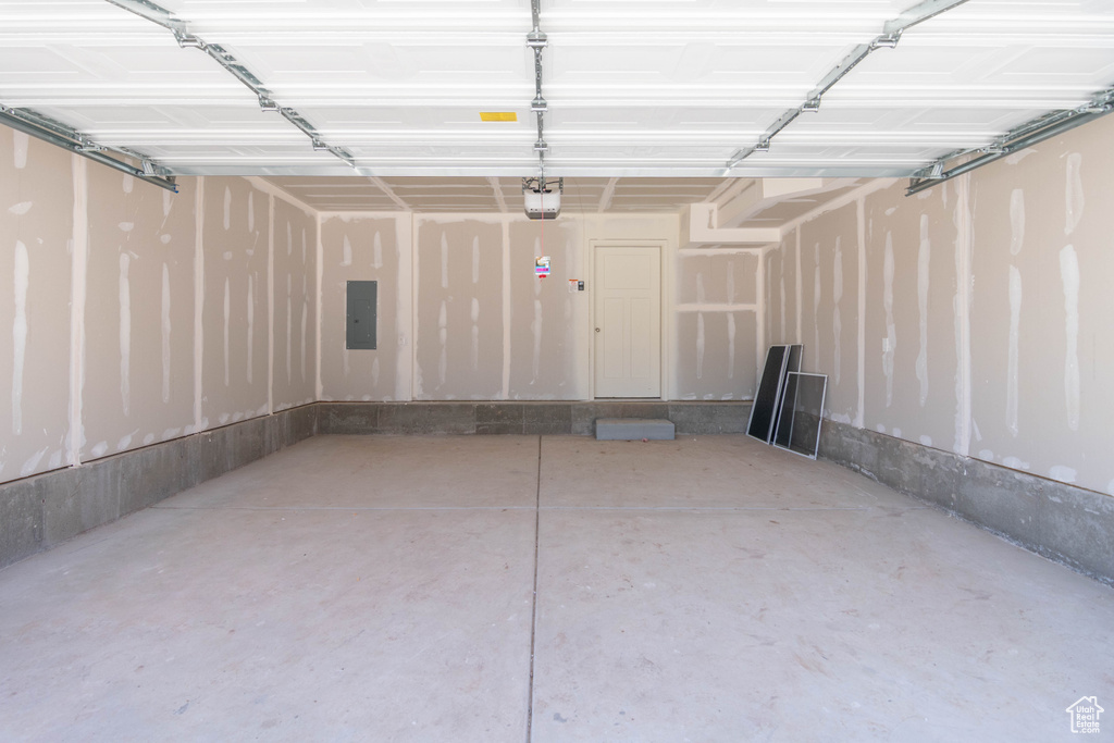 Garage featuring a garage door opener and electric panel