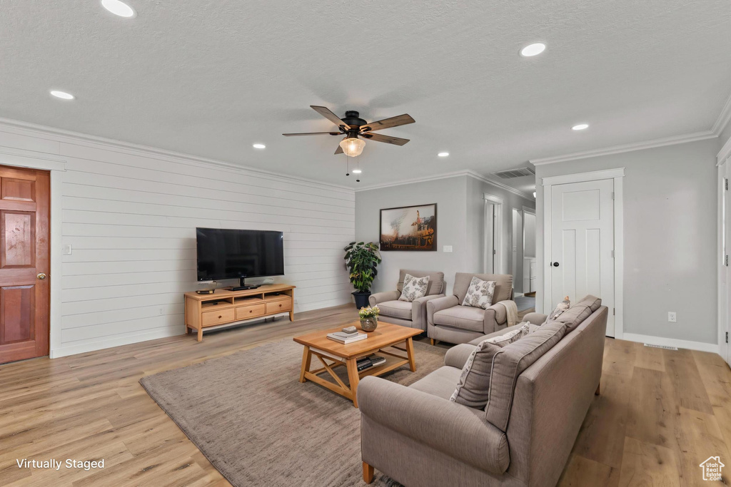 Living area featuring crown molding, ceiling fan, light wood-style floors, recessed lighting, and baseboards