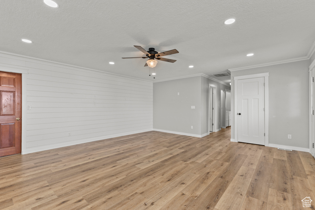 Unfurnished living room featuring ceiling fan, crown molding, light wood-style flooring, recessed lighting, and baseboards