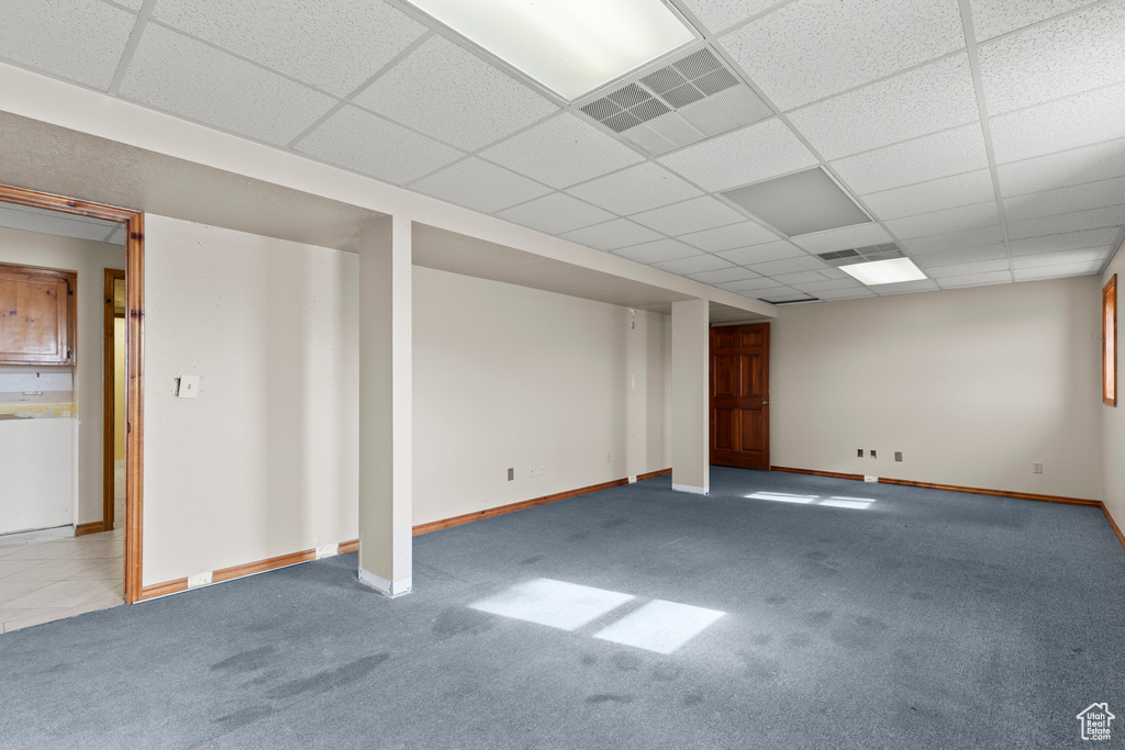 Basement with carpet, baseboards, and a paneled ceiling
