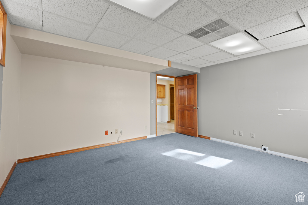 Carpeted empty room with baseboards and a paneled ceiling