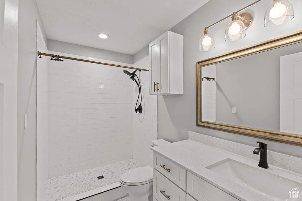 Full bath with a stall shower, toilet, vanity, and recessed lighting