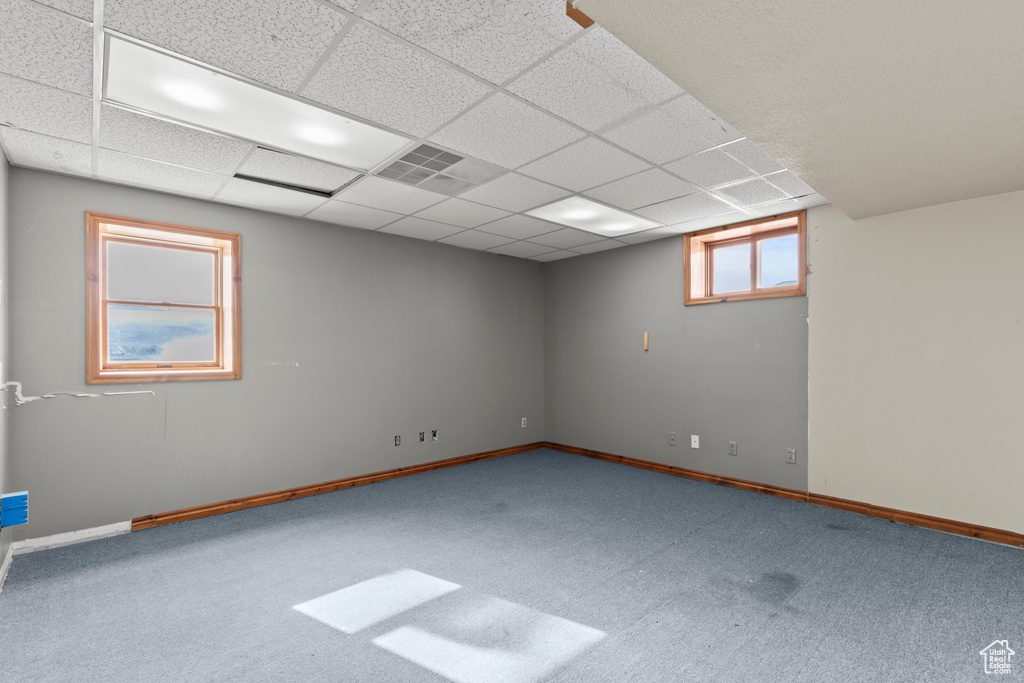 Carpeted spare room with baseboards and a paneled ceiling