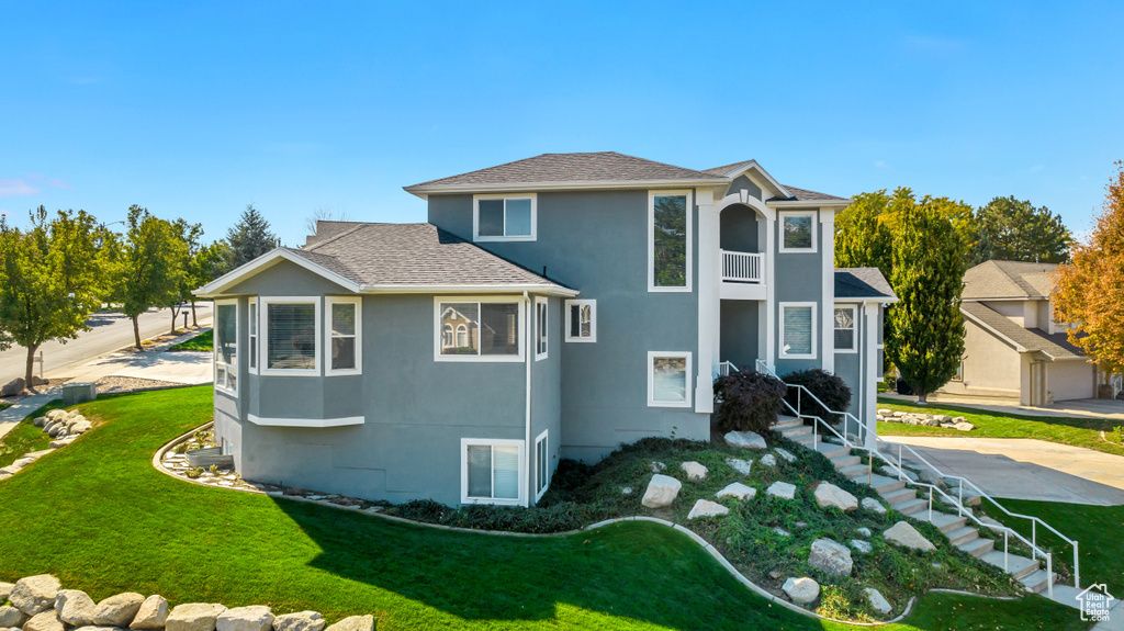 View of front facade featuring a garage and a front lawn