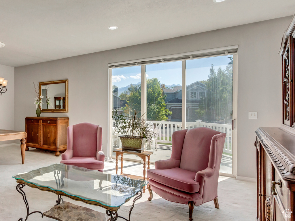 Living room featuring light colored carpet and an inviting chandelier