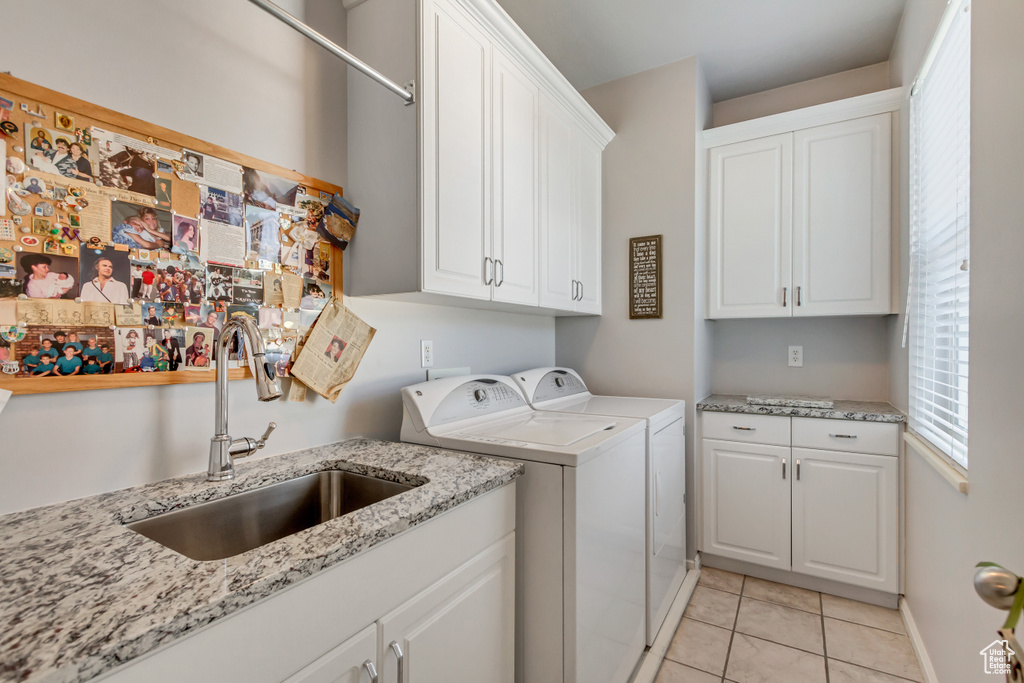 Laundry area featuring cabinets, sink, washing machine and clothes dryer, and light tile patterned flooring