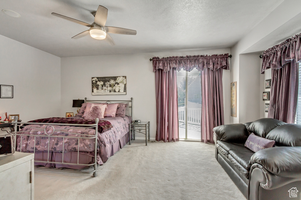 Carpeted bedroom featuring access to outside, a textured ceiling, and ceiling fan