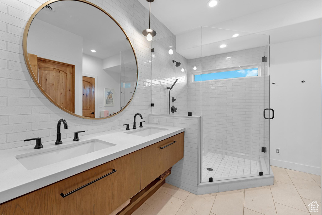 Bathroom featuring vanity, backsplash, an enclosed shower, and tile patterned floors