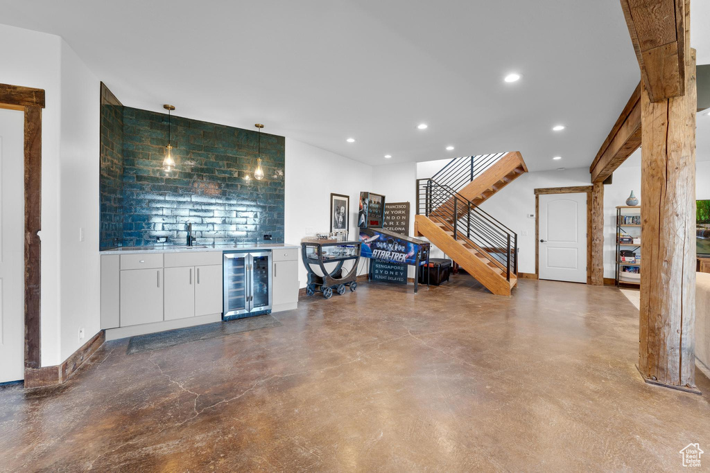 Living room with wine cooler, indoor bar, and concrete floors