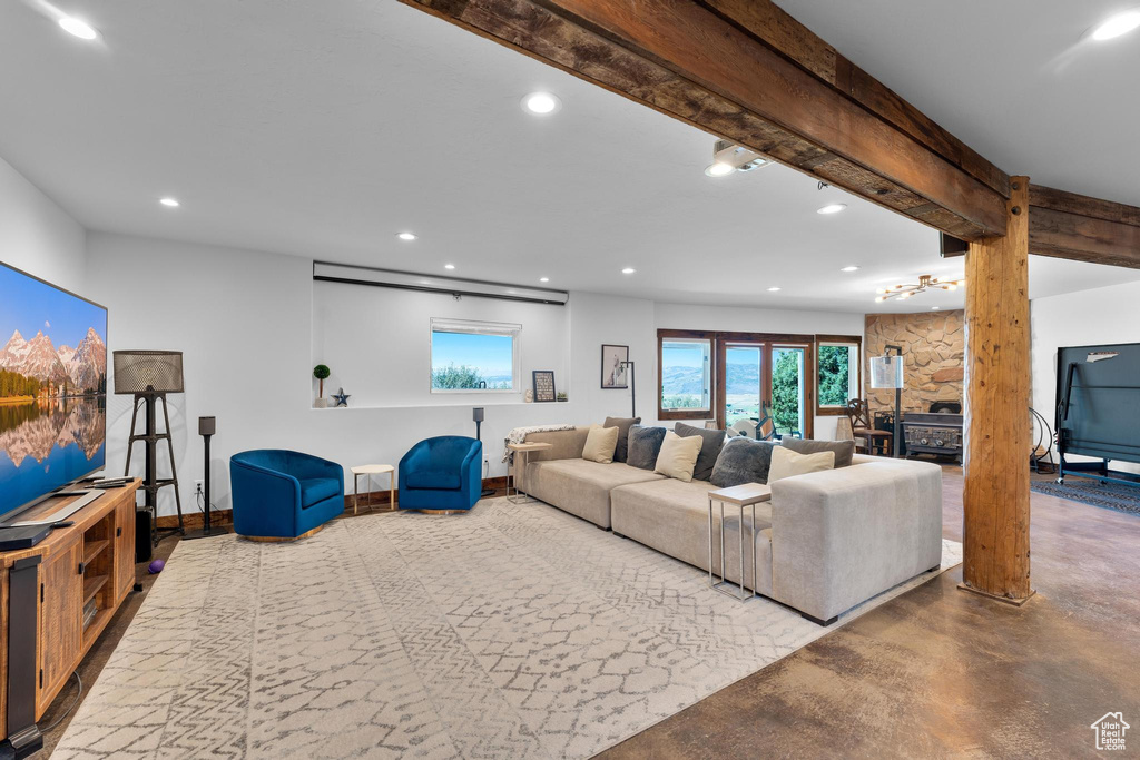 Living room featuring beamed ceiling and concrete flooring