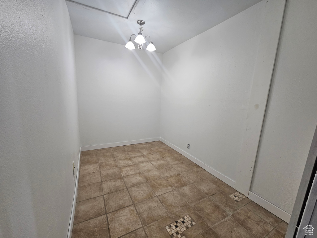 Unfurnished room featuring an inviting chandelier