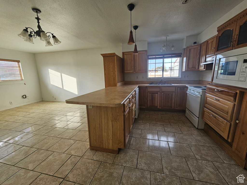 Kitchen featuring pendant lighting, sink, stainless steel appliances, and an inviting chandelier