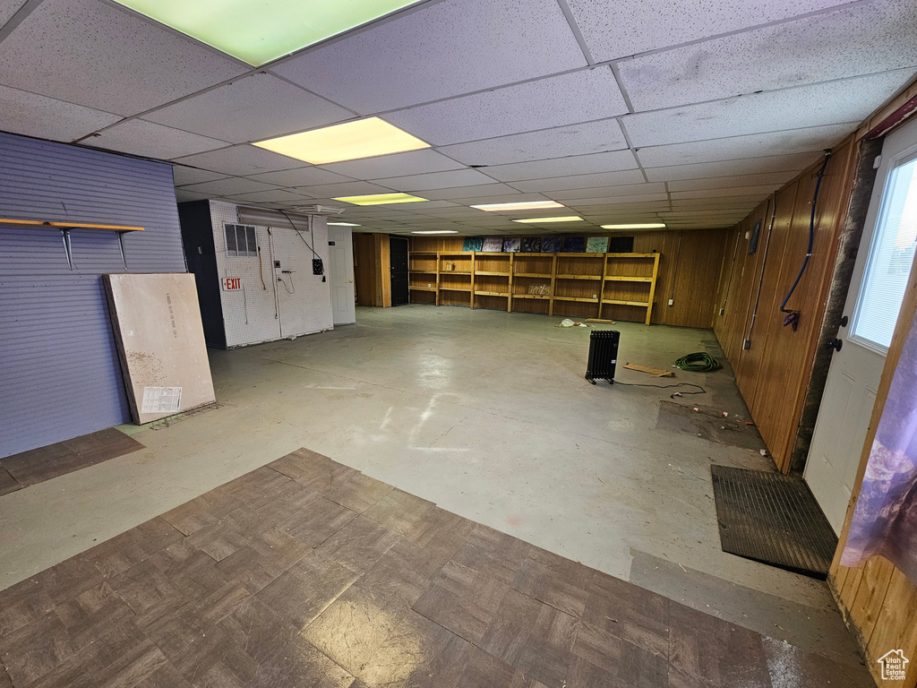 Basement with wooden walls and a drop ceiling