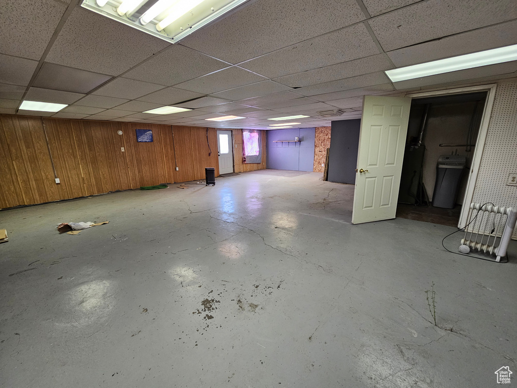 Basement with a paneled ceiling and wood walls