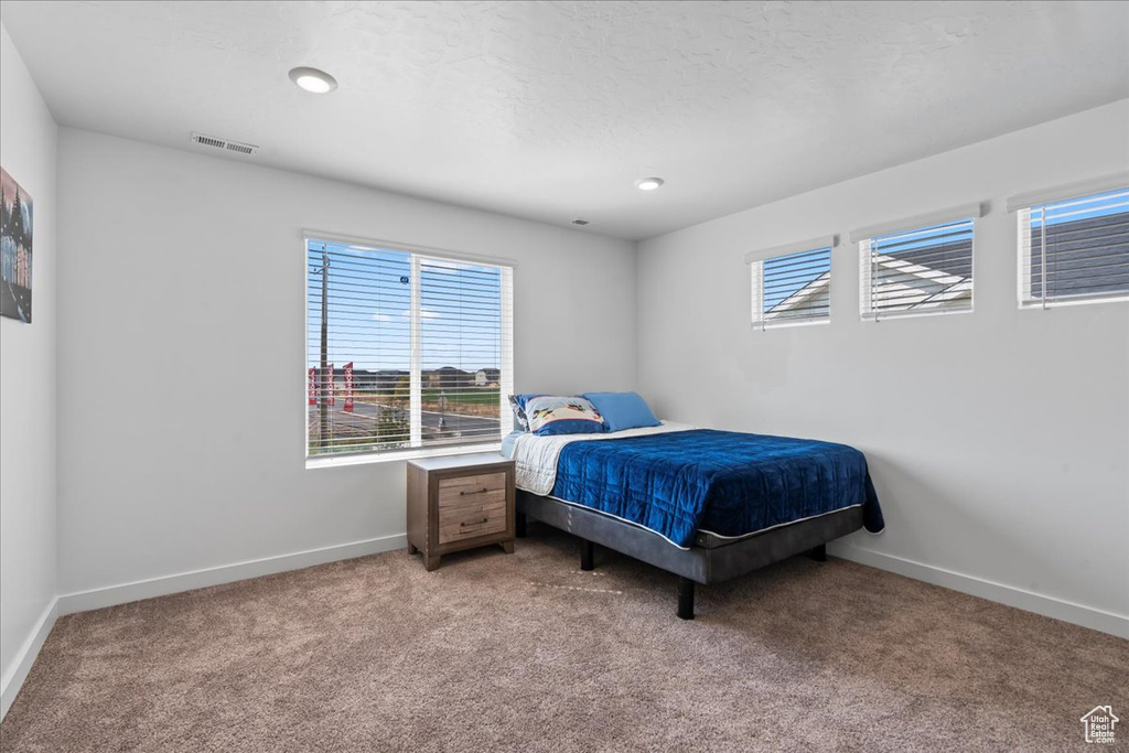 Bedroom featuring carpet and a textured ceiling