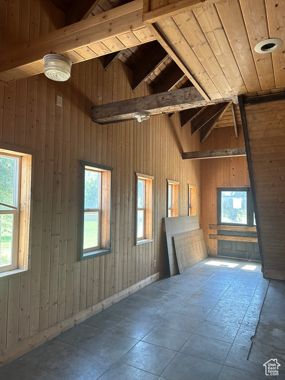 Interior space with wooden ceiling, vaulted ceiling with beams, and wooden walls