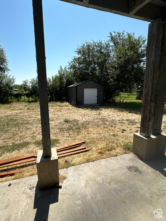 View of yard featuring a garage and an outbuilding