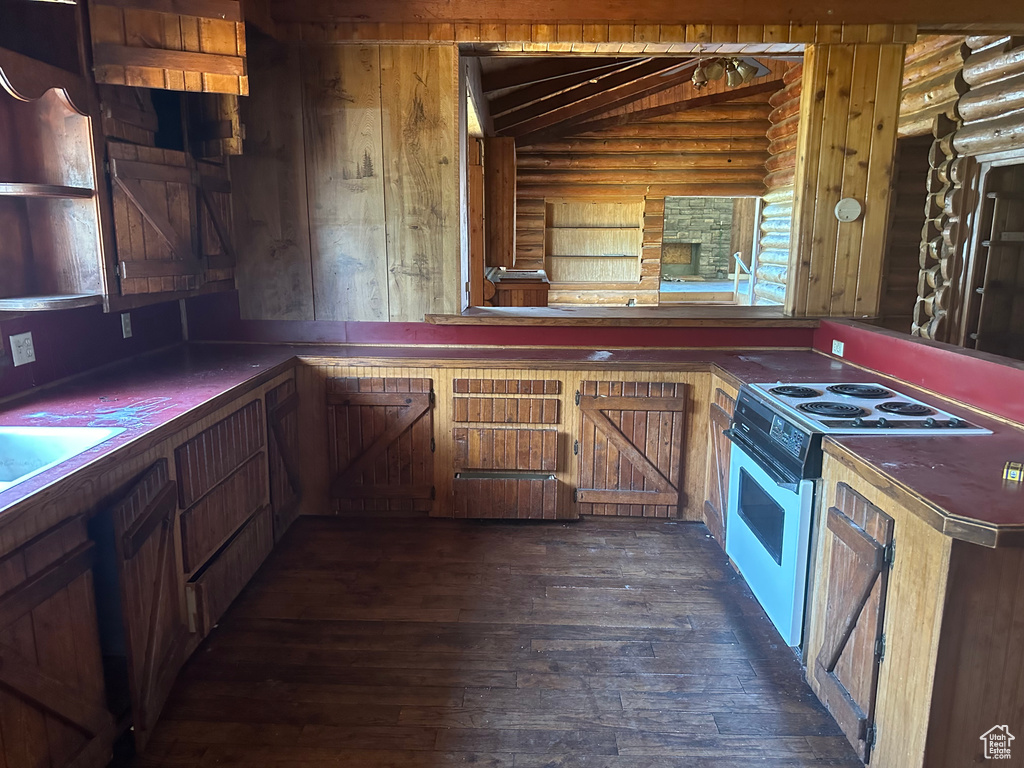 Kitchen with white electric range, dark hardwood / wood-style flooring, log walls, and lofted ceiling