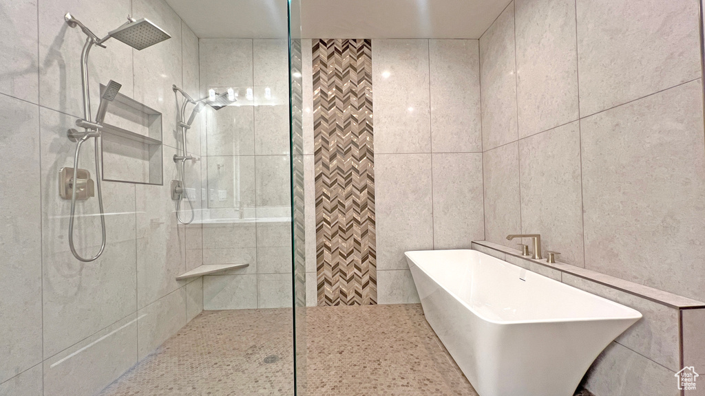 Bathroom with tile walls and separate shower and tub