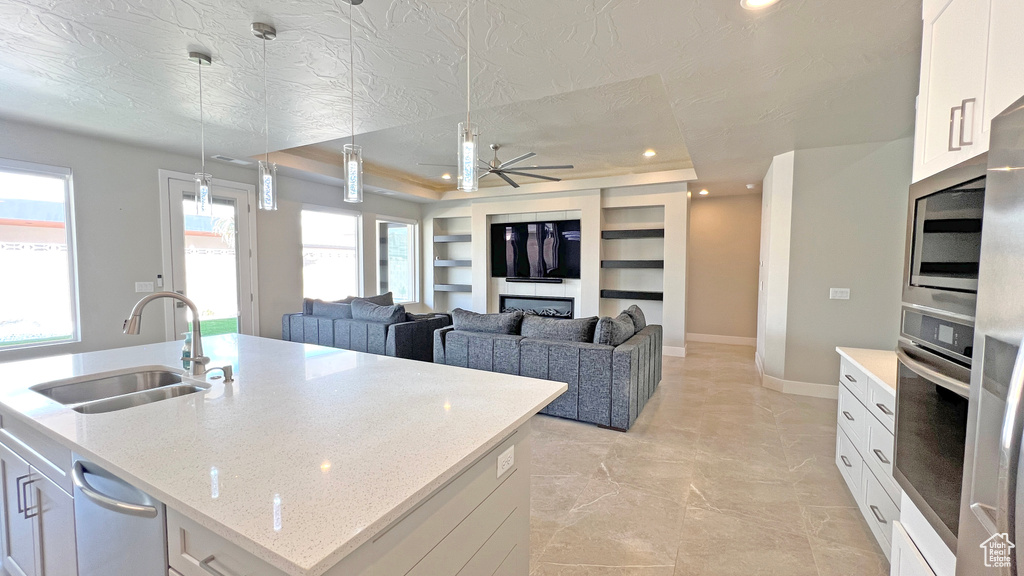 Kitchen with a textured ceiling, sink, ceiling fan, appliances with stainless steel finishes, and white cabinets