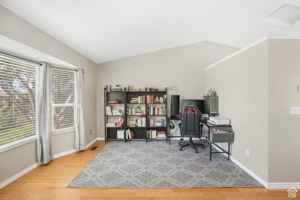 Office area featuring lofted ceiling and light hardwood / wood-style flooring