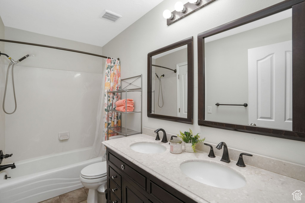 Full bathroom featuring tile patterned flooring, vanity, toilet, and shower / bathtub combination with curtain