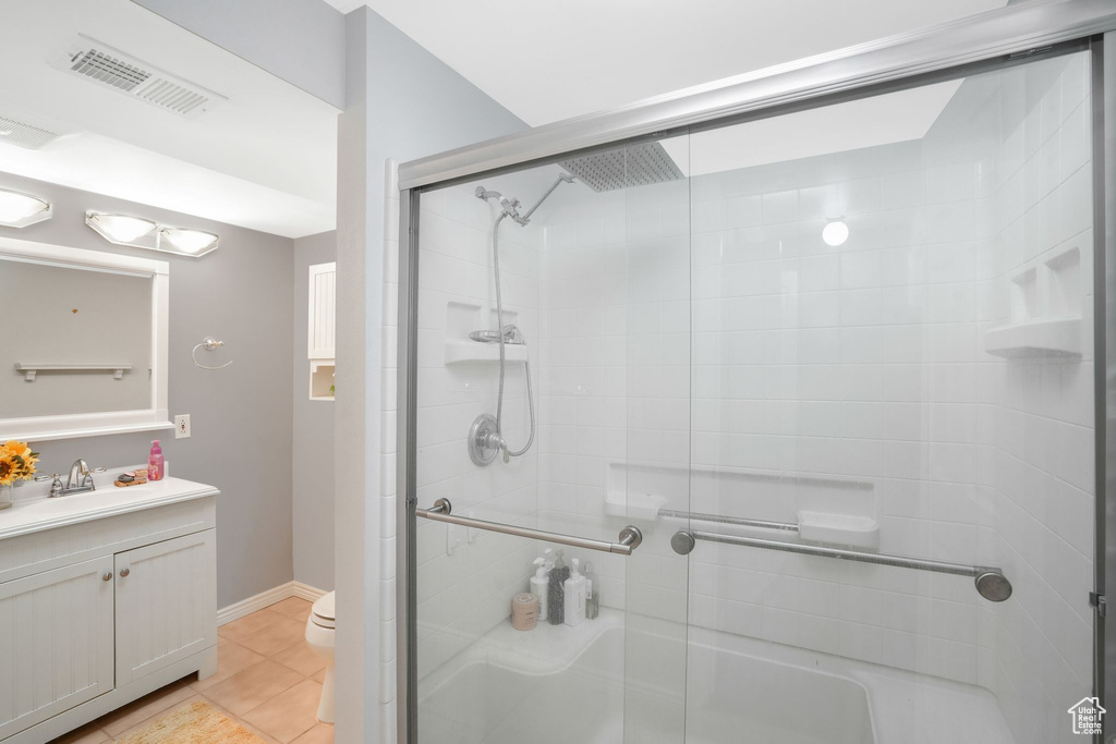 Bathroom featuring toilet, a shower with door, and vanity