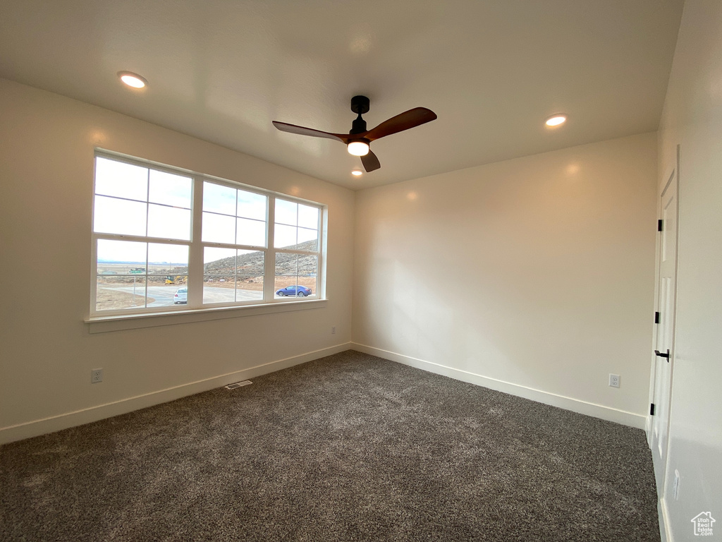 Carpeted empty room featuring ceiling fan