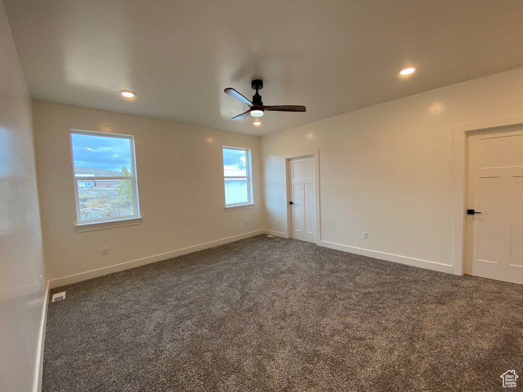 Carpeted spare room featuring ceiling fan