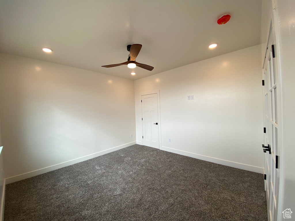 Unfurnished room featuring ceiling fan and carpet floors