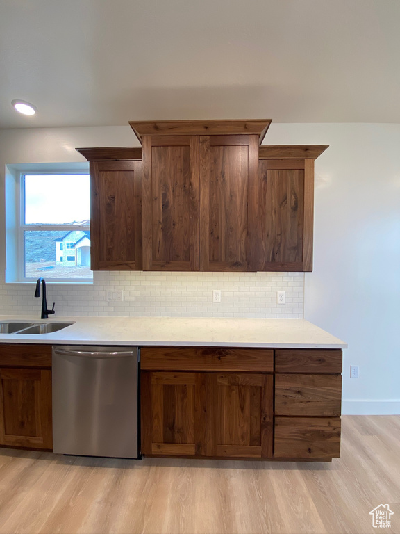 Kitchen featuring light hardwood / wood-style flooring, backsplash, dishwasher, and sink