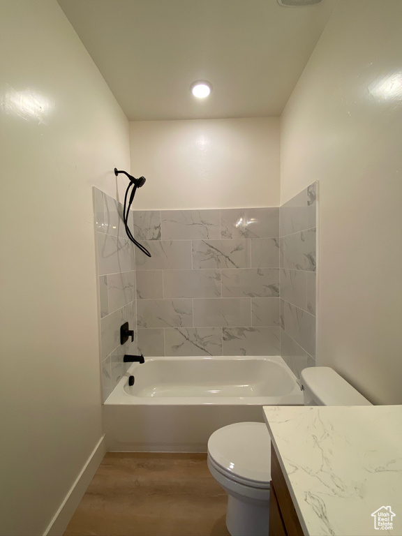 Full bathroom featuring tiled shower / bath, vanity, toilet, and hardwood / wood-style floors